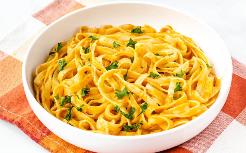 close up of pumpkin pasta in white bowl