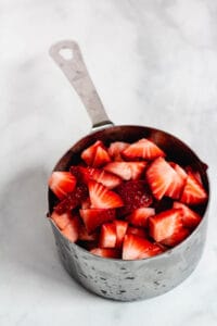chopped strawberries in measuring cup