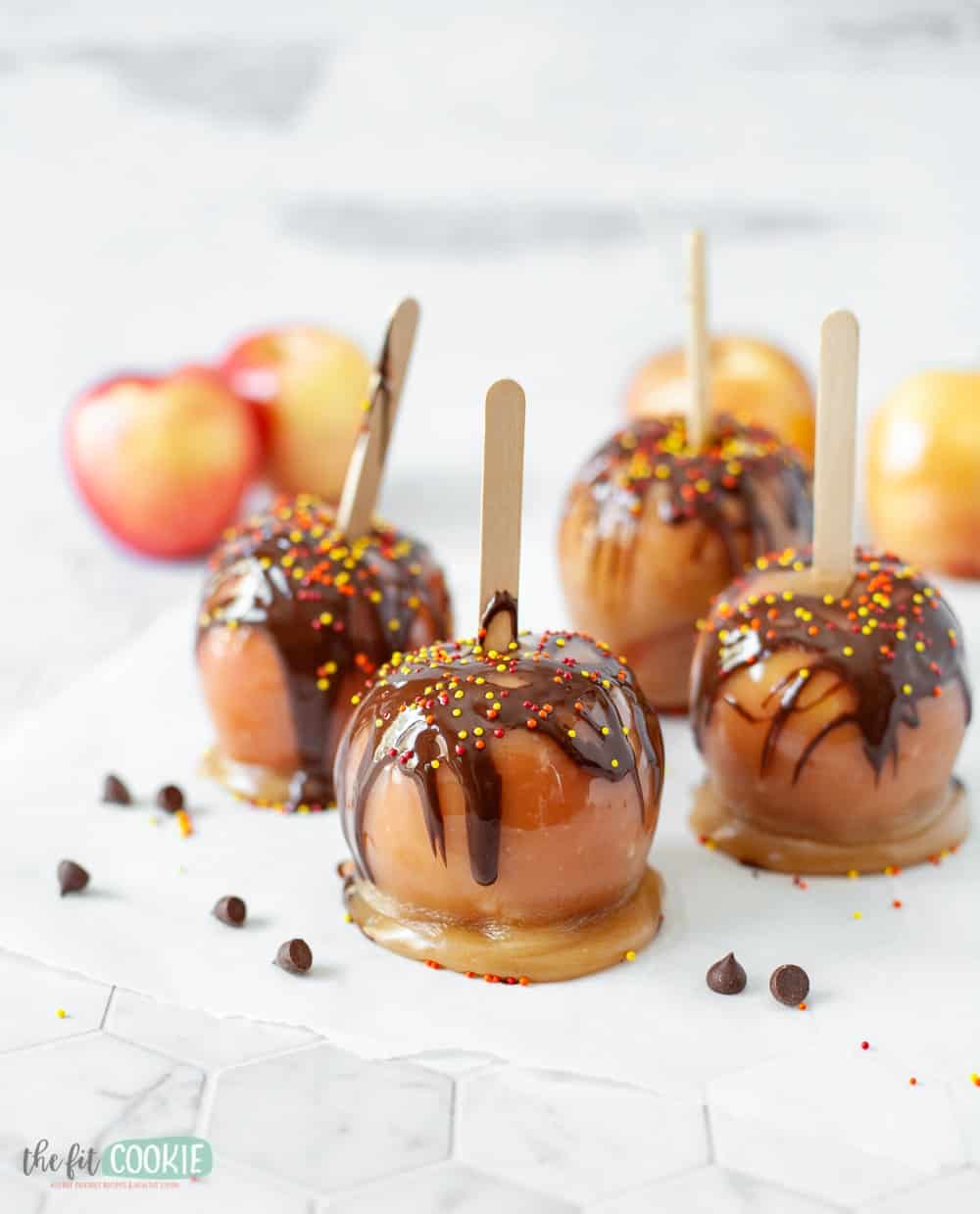 Caramel apples with chocolate and sprinkles.