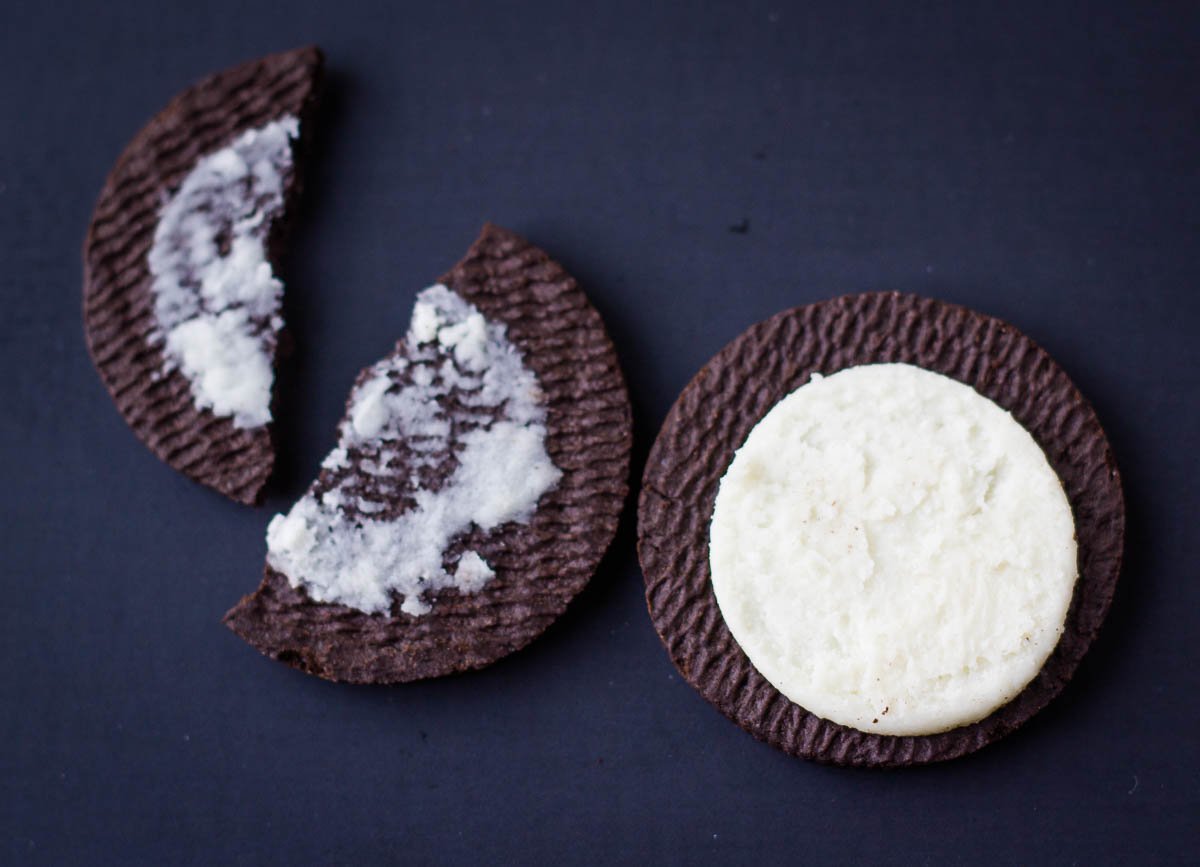 Oreo cookie half broken in half, and one side with cream.