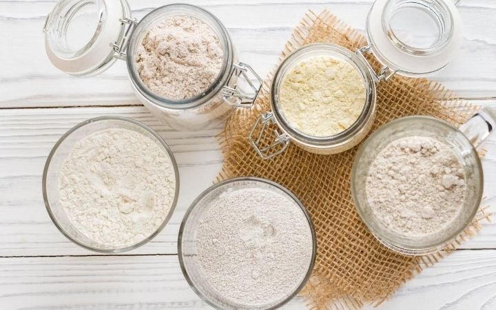 Different types of flour in glass bowls. 