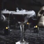 Black martini in martini glass with smoke.