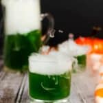 Green cocktail with dry ice smoke.