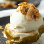 Baked apple half topped with ice cream and granola.