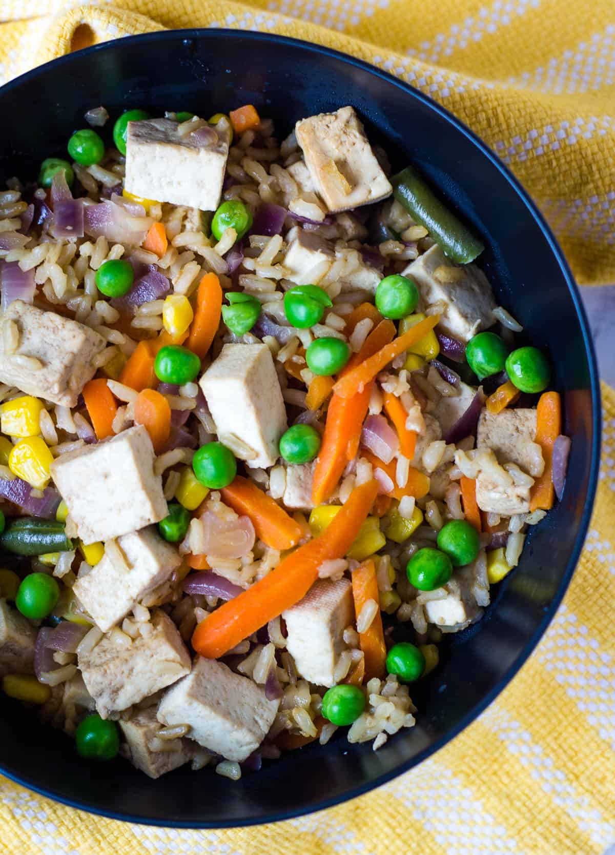 vegan fried rice with tofu in black bowl