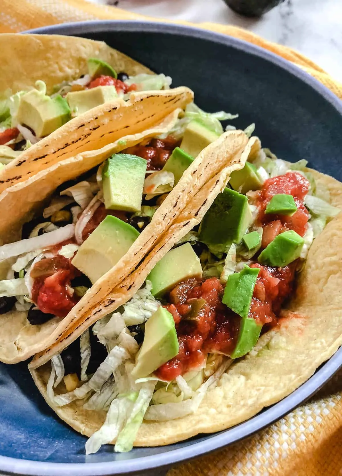 black bean tacos topped with lettuce salsa, and avocado