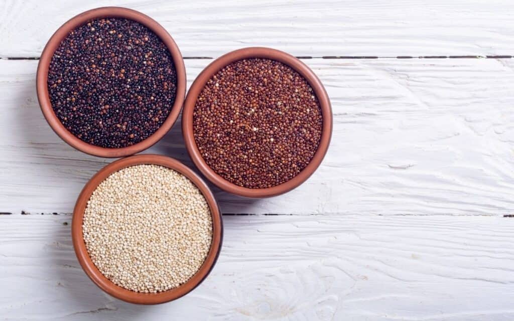 red, white, and black quinoa in small bowls