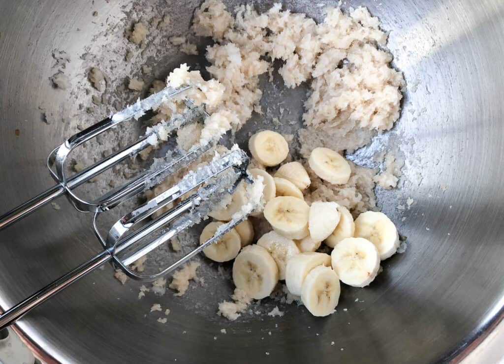 bananas and shortening in metal bowl with hand mixer
