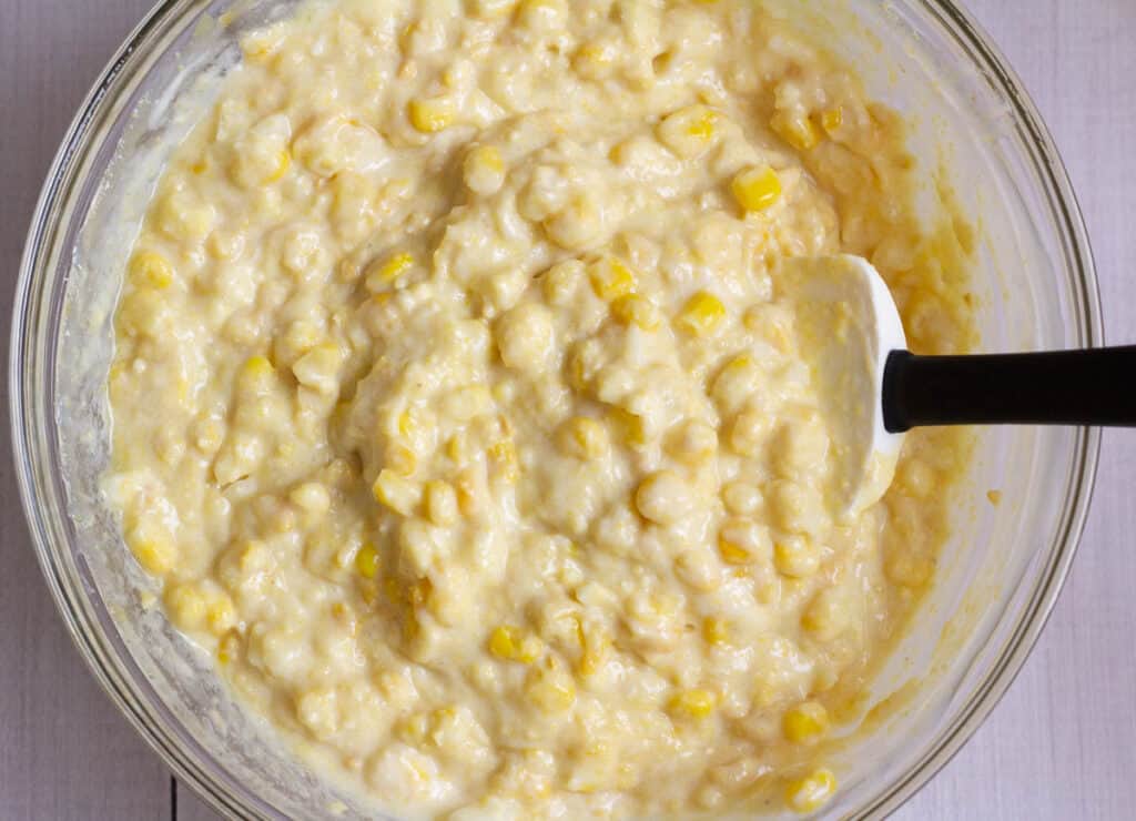 corn casserole ingredients combined in a glass bowl