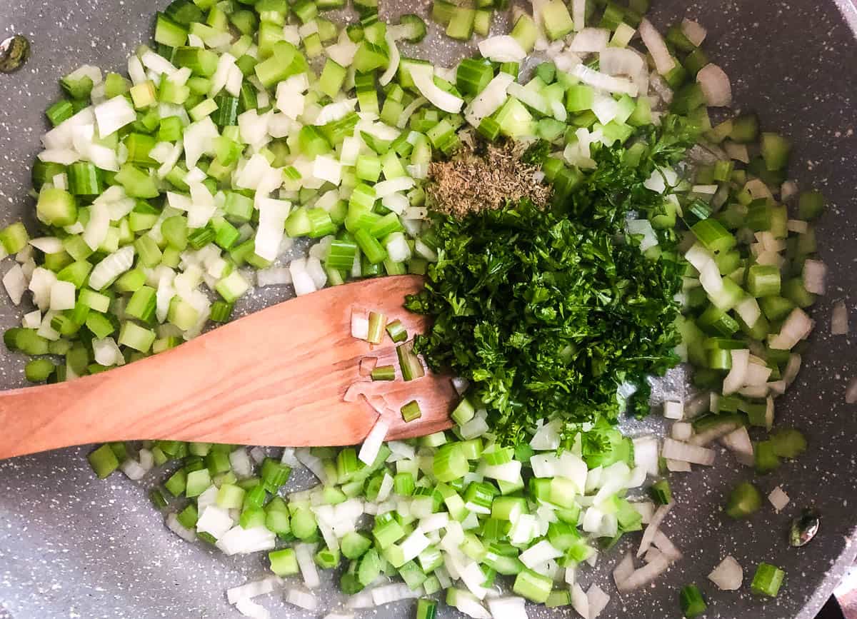 Spices and parsley in pan with celery and onions.