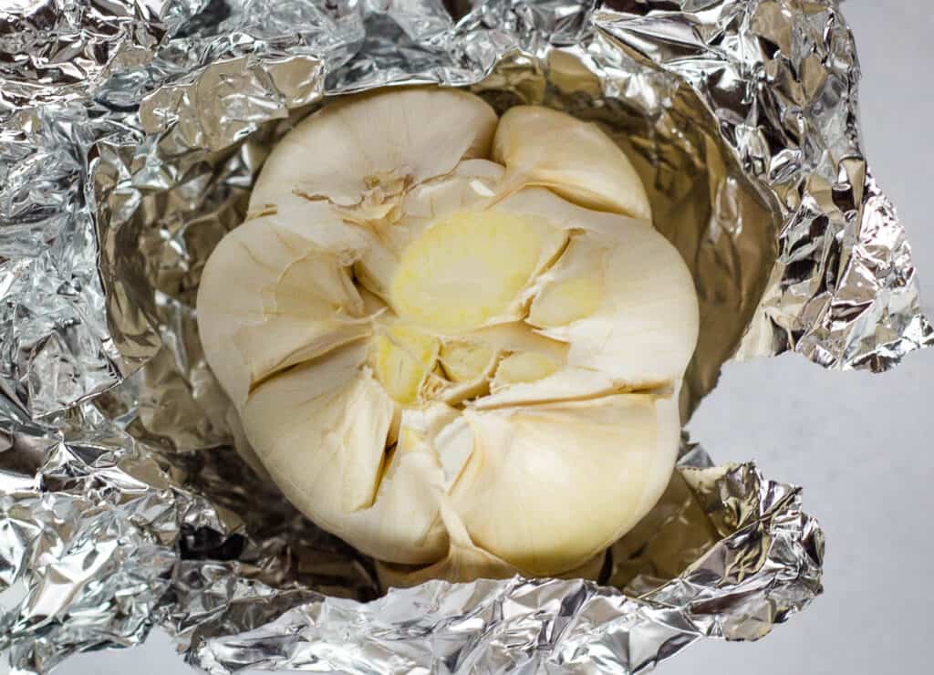 head of garlic wrapped in aluminum foil