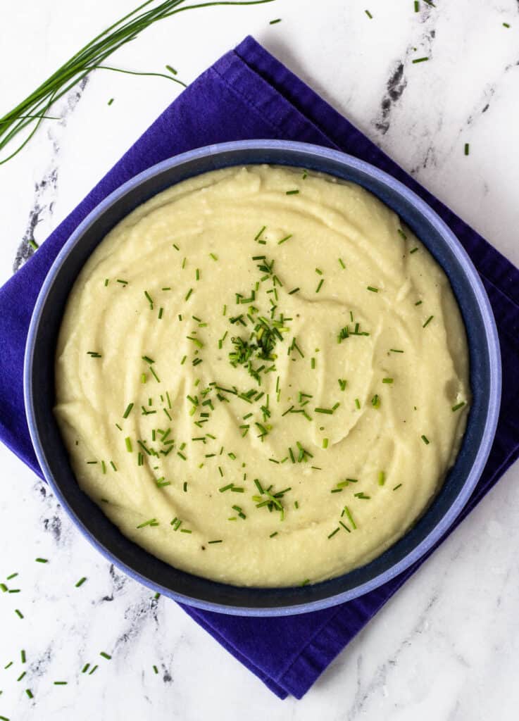 mashed potatoes with almond milk in bowl, sprinkled with chives