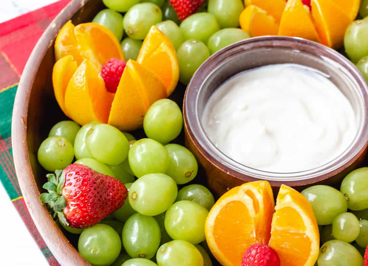 Fruit platter with grapes oranges and strawberries with yogurt dipping sauce.