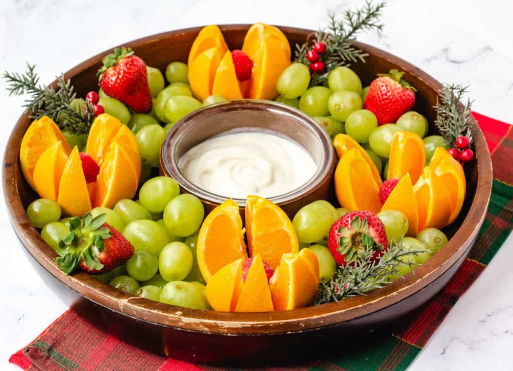 Christmas fruit platter with grapes, oranges, strawberries, and raspberries