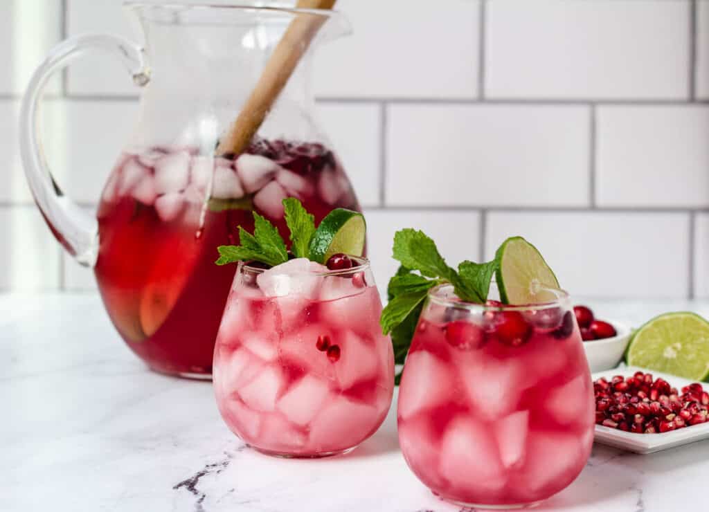 2 cranberry mocktails garnished with lime, mint, and fresh cranberries