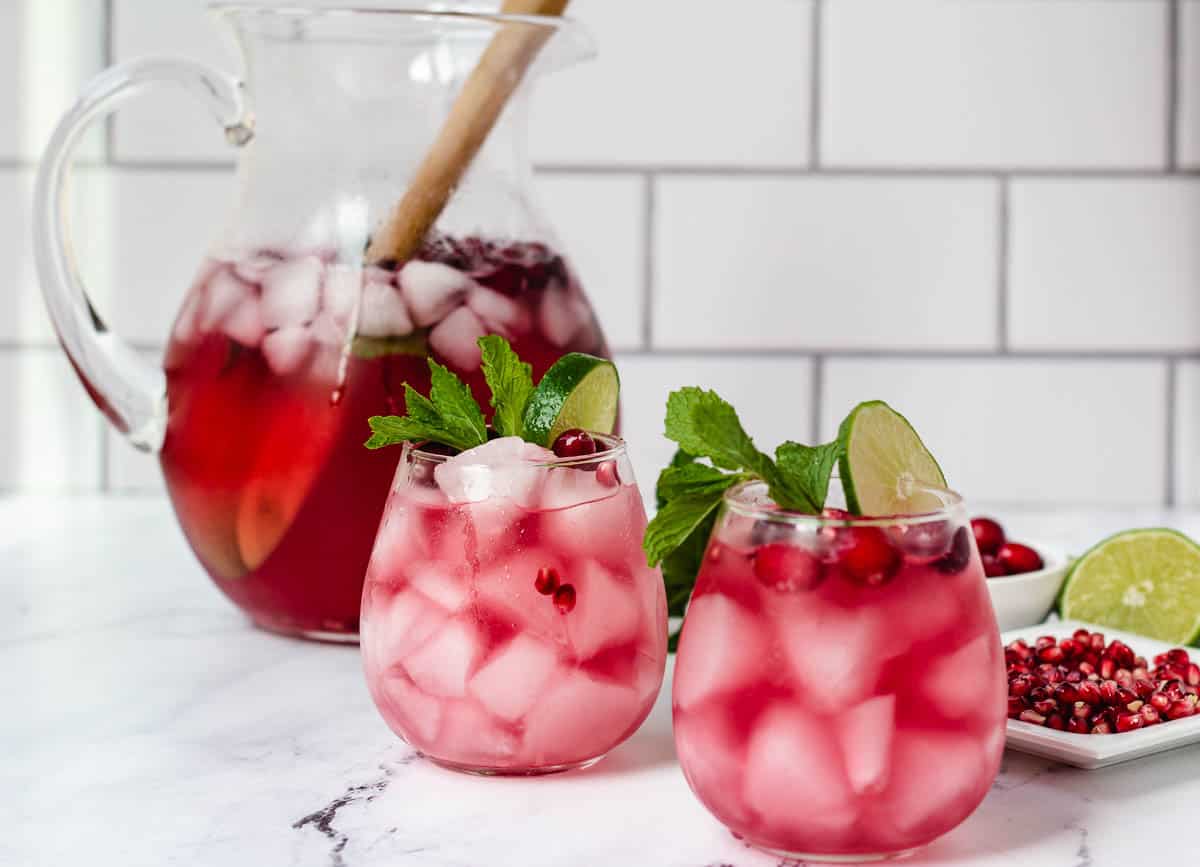 Two cranberry mocktails in stemless wine glasses.