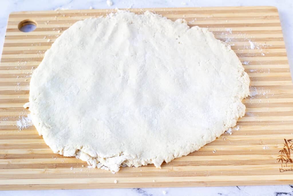 flattened dough on cutting board