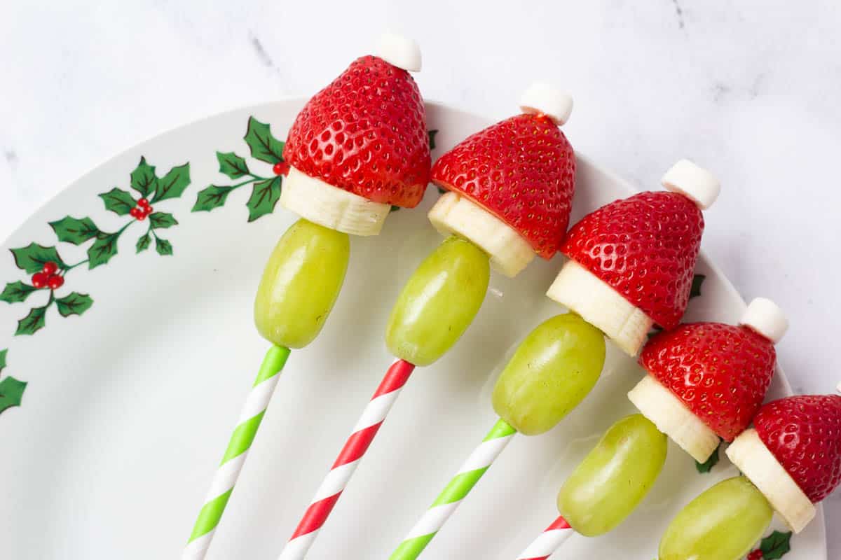 Grinch fruit kabobs on Christmas serving tray. 