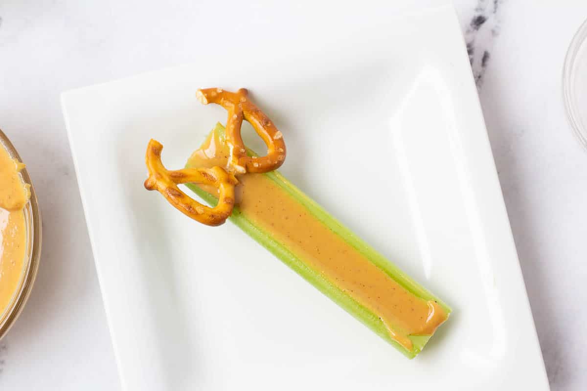 Pretzel pieces on top of peanut butter celery stick.