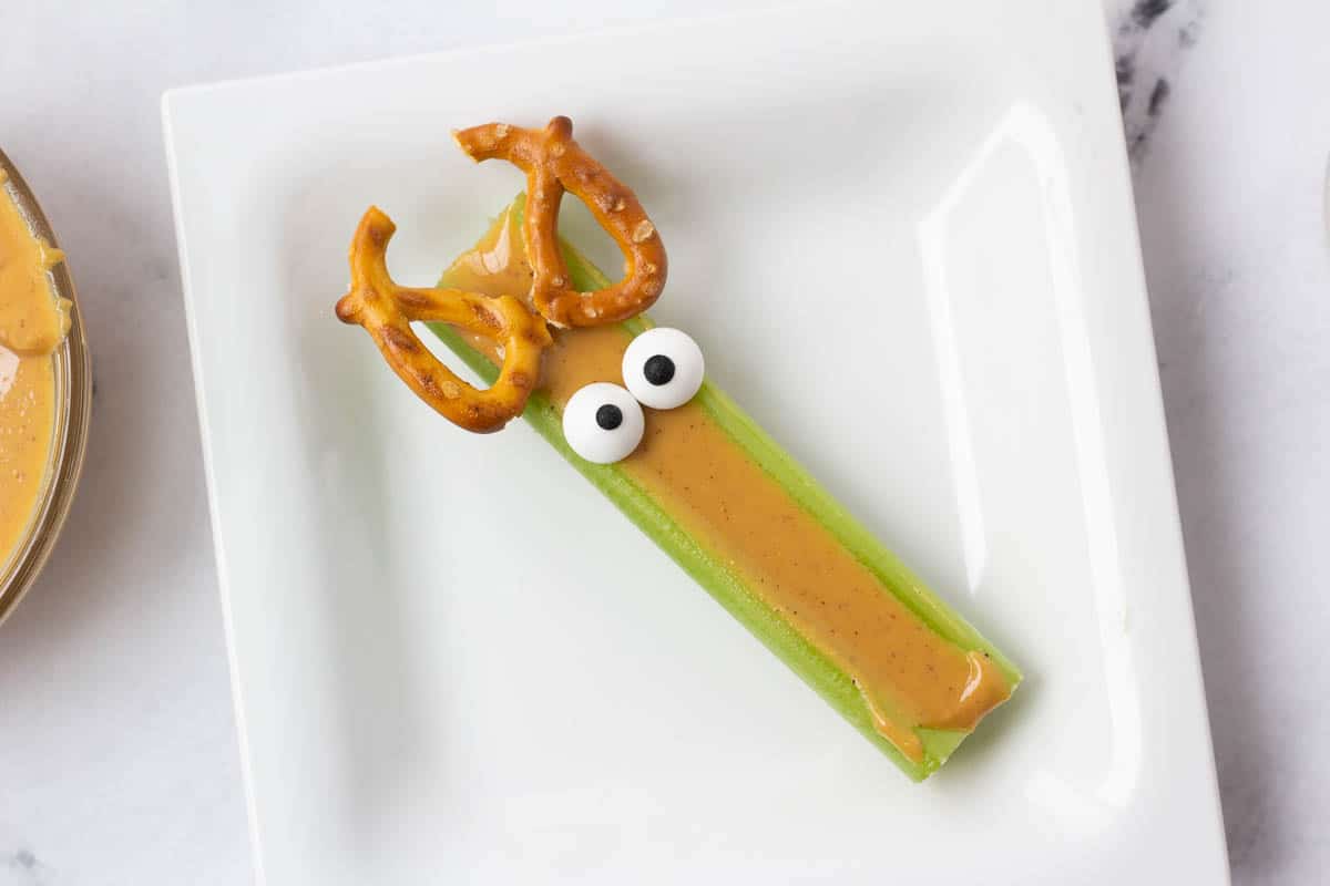 celery stick with pretzels and candy eyes