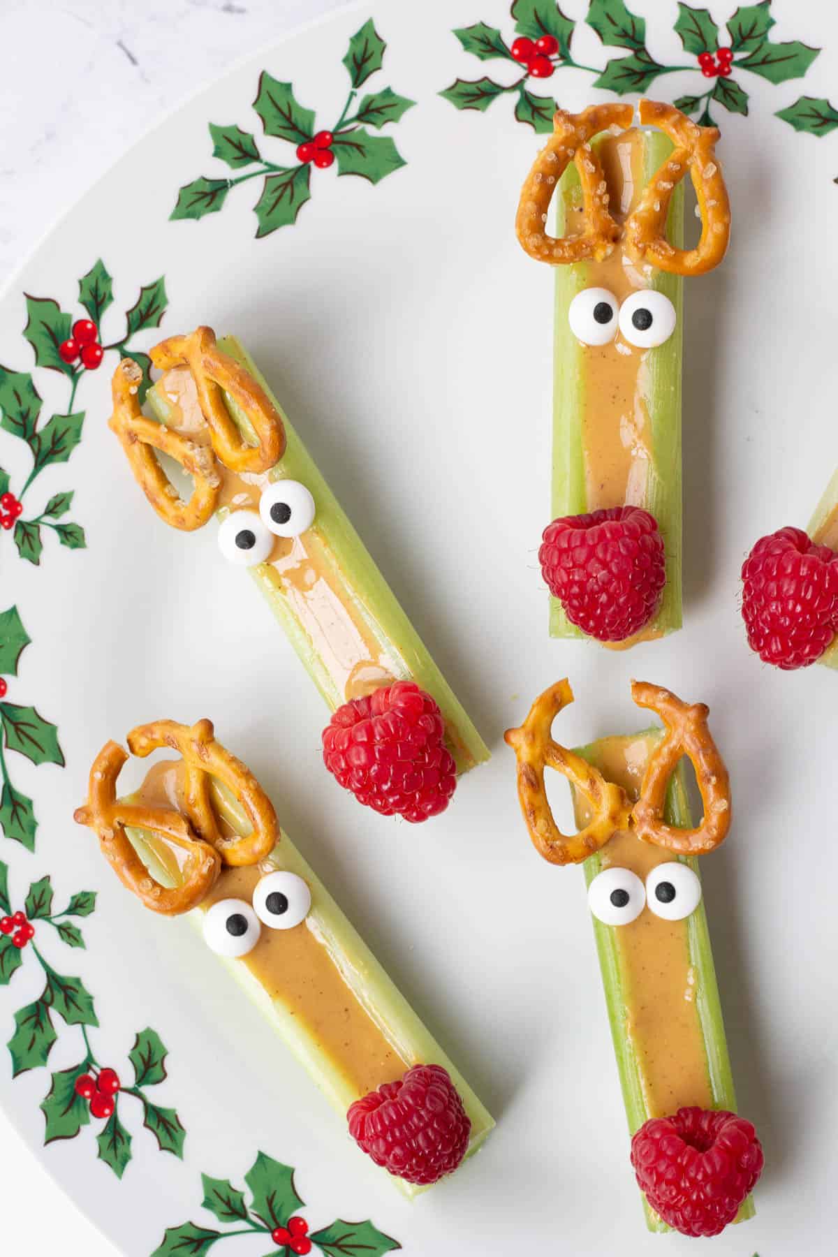 reindeer celery snacks with peanut butter, pretzels, candy eyes, and a raspberry nose