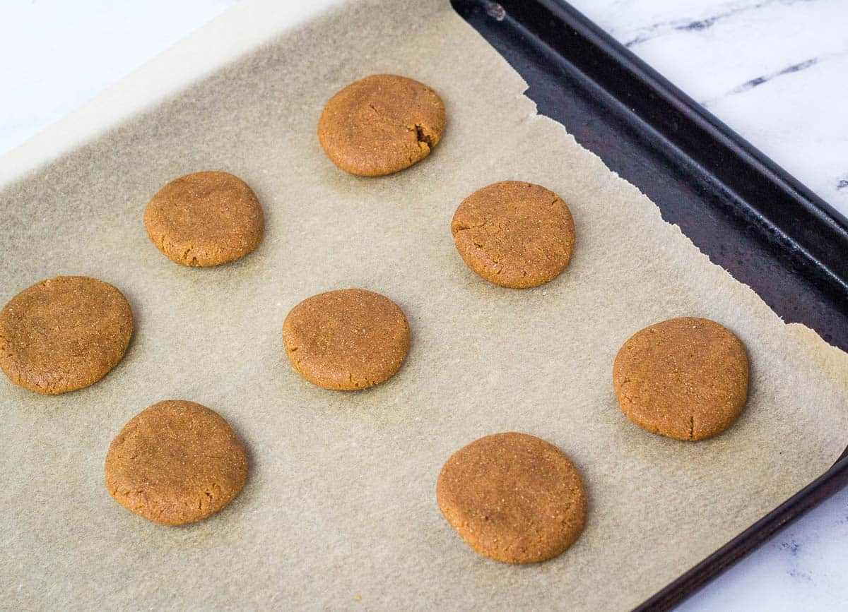 Ginger cookie dough rounds on baking sheet.