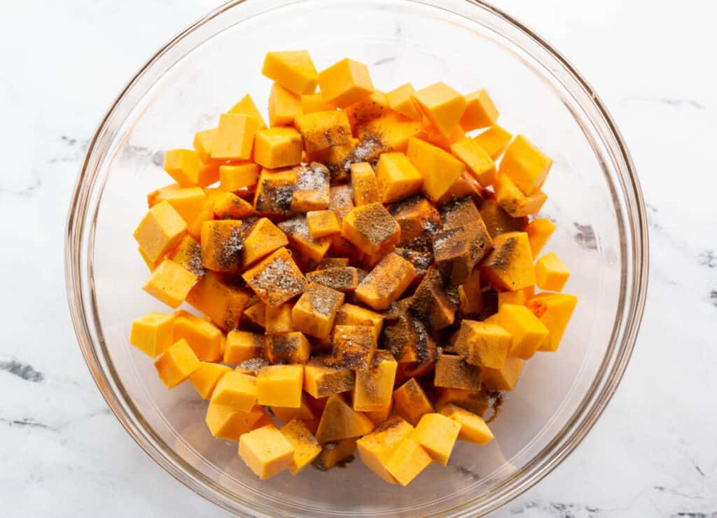 butternut squash in glass bowl topped with spices