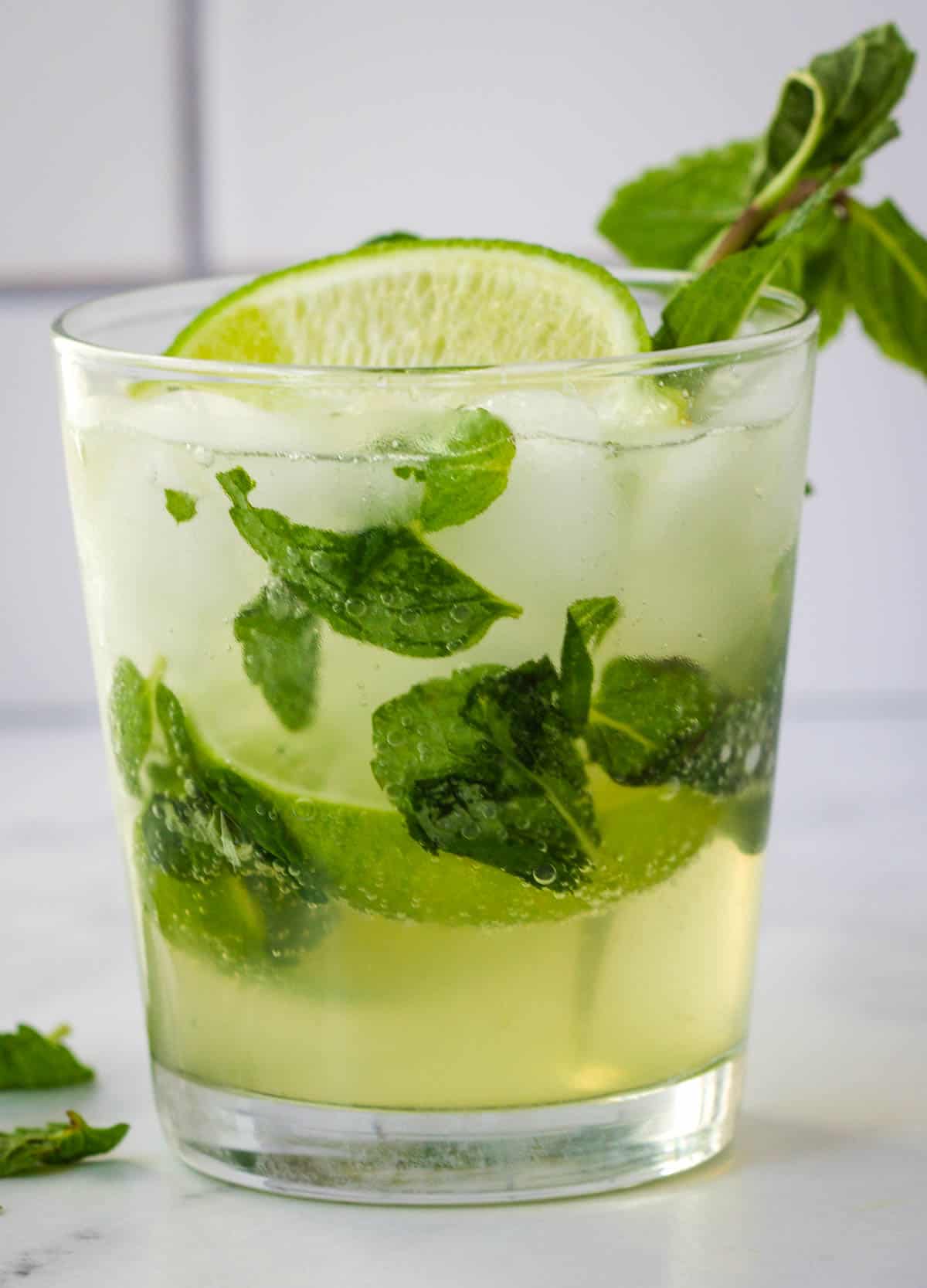 Mojito mocktail in glass served with mint and lime.