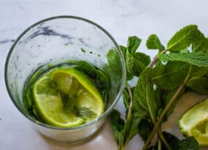 mint and lime muddled in glass