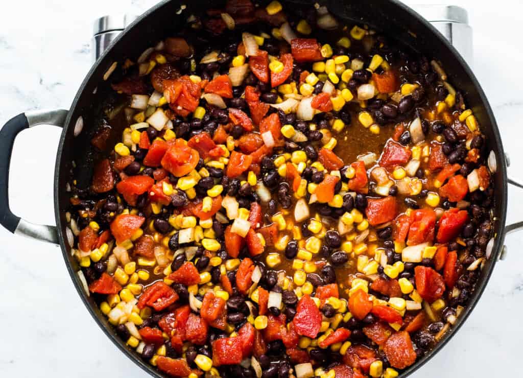 corn, tomatoes, black beans, and onion in pan