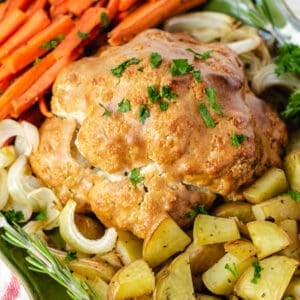 vegan roast dinner with cauliflower, potatoes, carrots, and onions