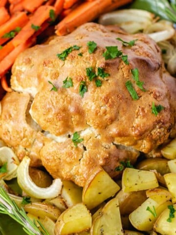 vegan roast dinner with cauliflower, potatoes, carrots, and onions