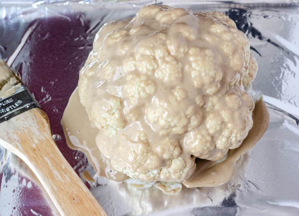head of cauliflower covered in tahini dressing
