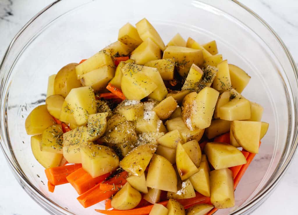 potatoes, carrots, and herbs in glass bowl