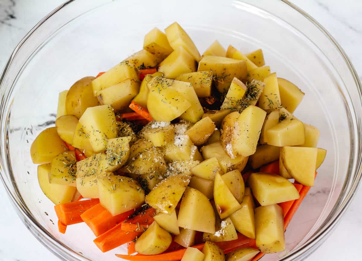 potatoes, carrots, and herbs in glass bowl