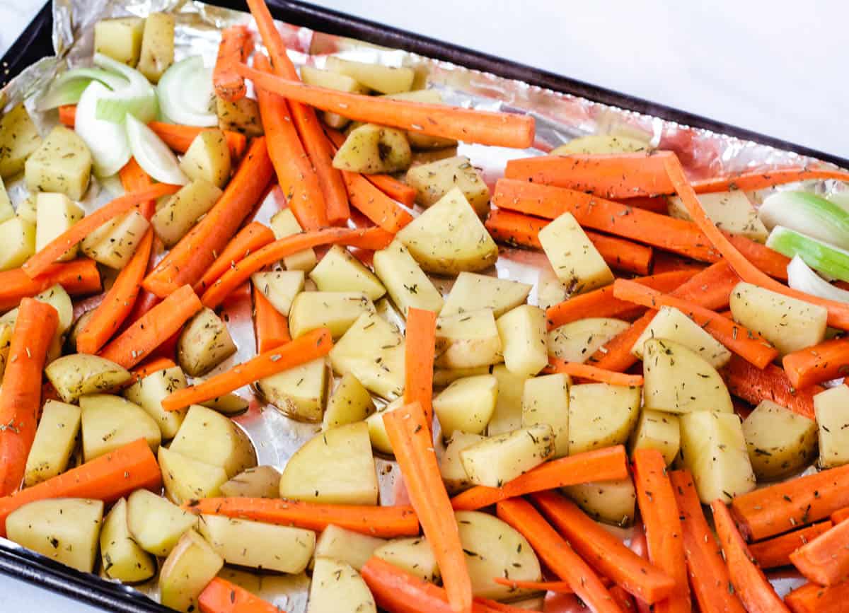 potatoes, carrots, and onion on baking sheet