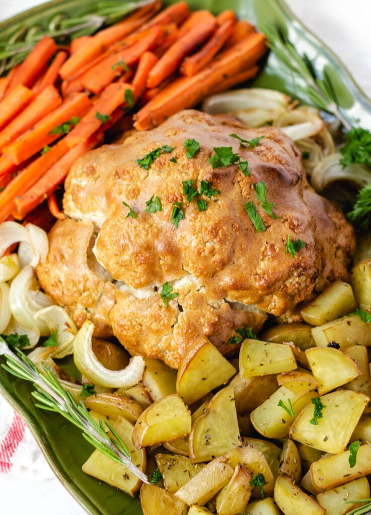 plant-based Christmas dinner: vegan roast dinner with cauliflower, potatoes, carrots, and onion