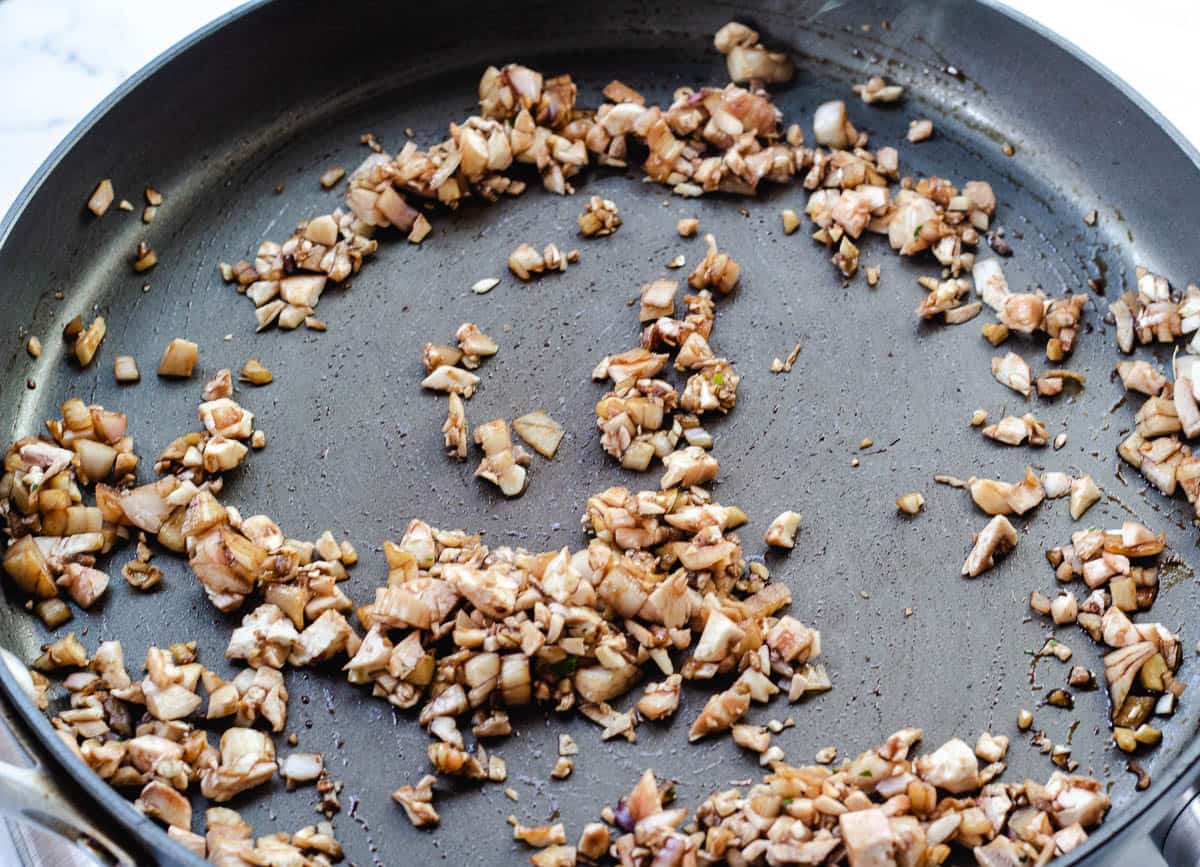 shallots, garlic, and mushroom stems in pan