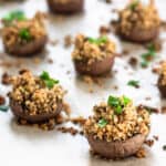 vegan stuffed mushrooms topped with parsley on parchment paper
