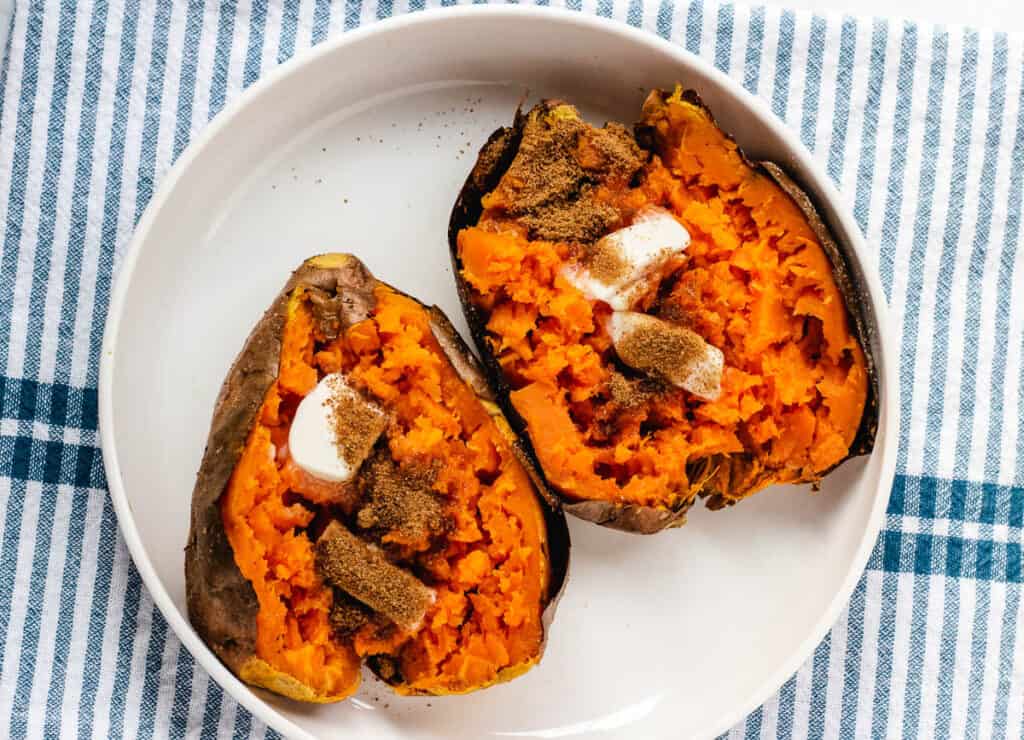 2 baked sweet potatoes topped with butter and brown sugar