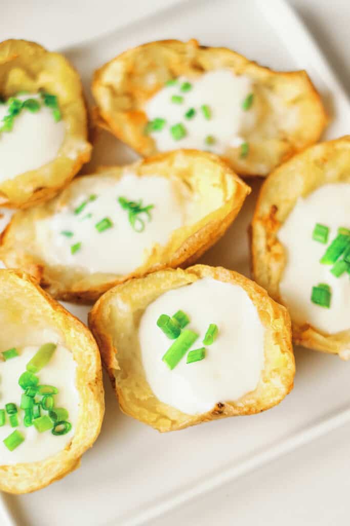 air fryer potato skins crowed together on white serving plate