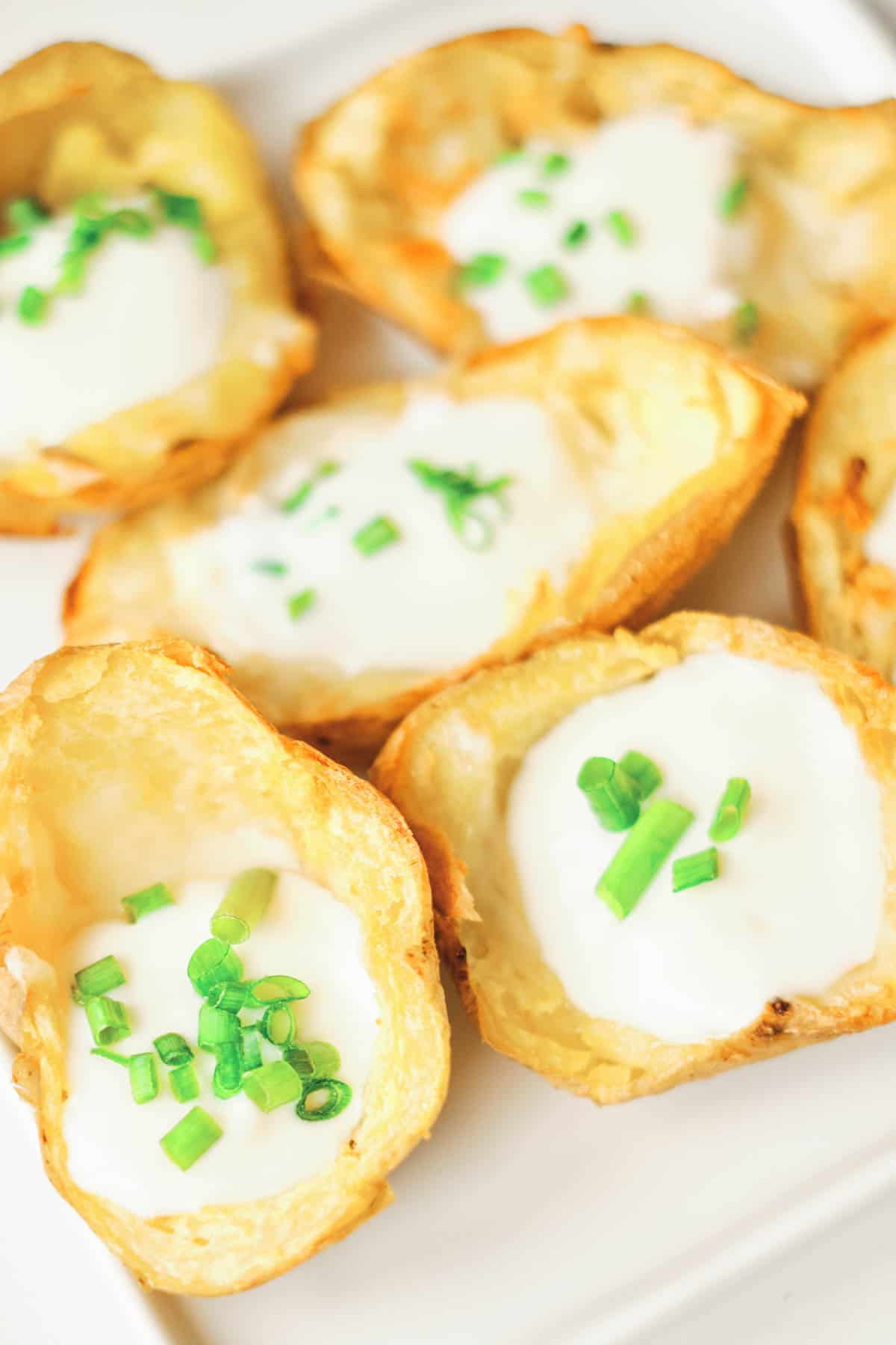 potato skins filled with cheese, sour cream, and topped with chives
