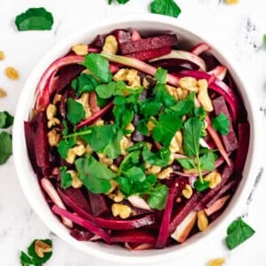 beetroot salad in white bowl topped with watercress
