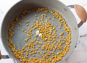 large pot with oil and corn kernels