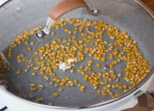covered pot with oil and corn kernels