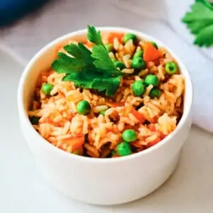 arroz rojo in small white bowl topped with cilantro