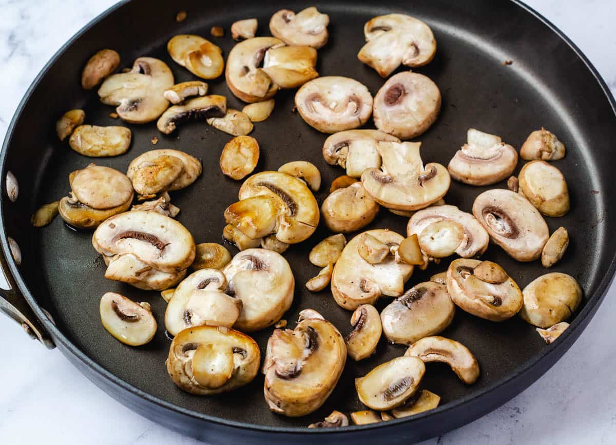 Sautéd mushrooms slices in pan.