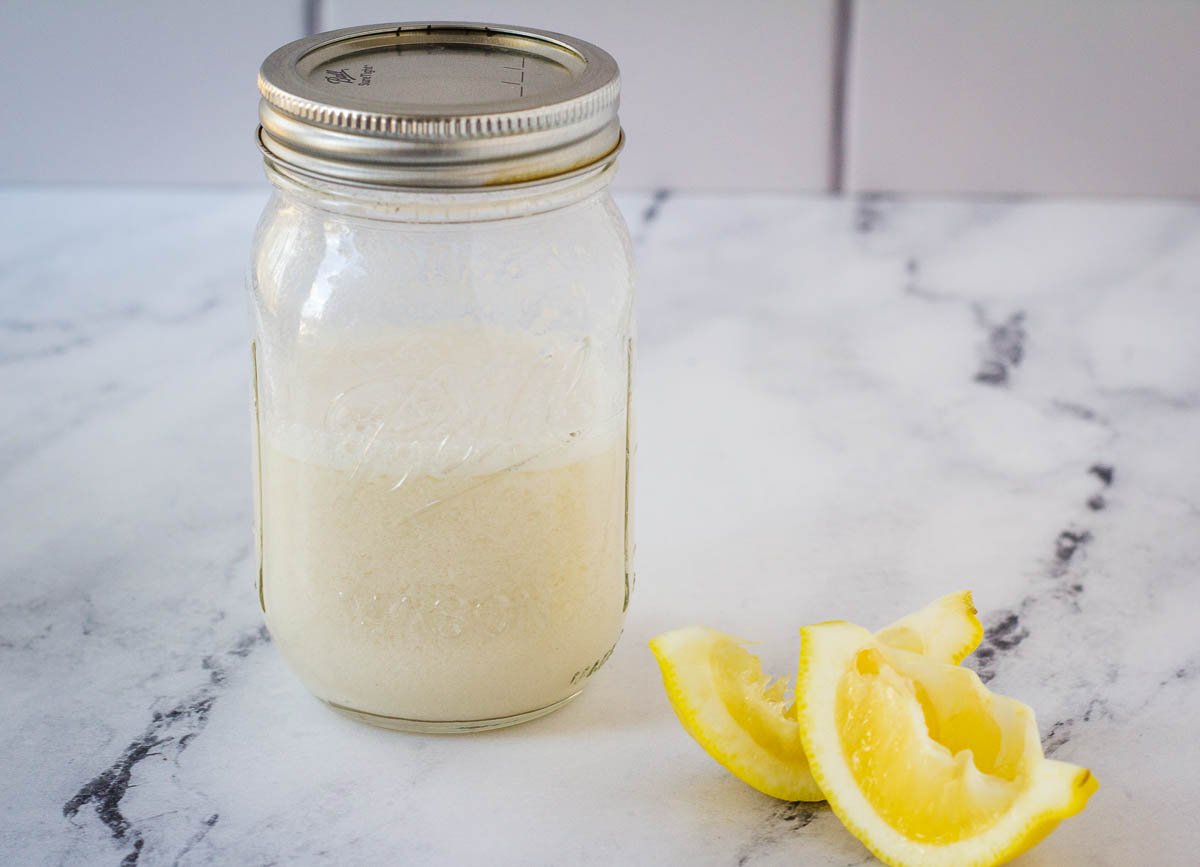 buttermilk in mason jar on marble counter next to lemon slices