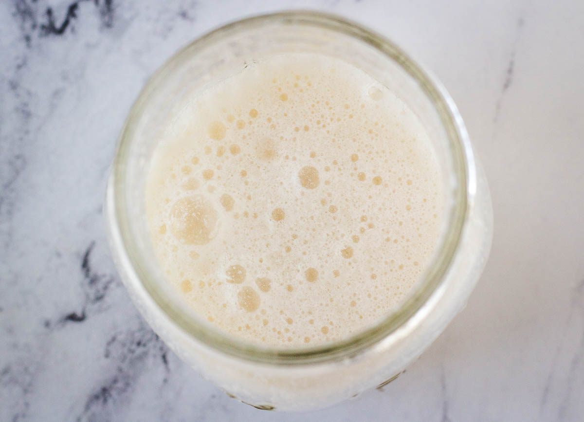 overhead of vegan buttermilk in mason jar on marble counter