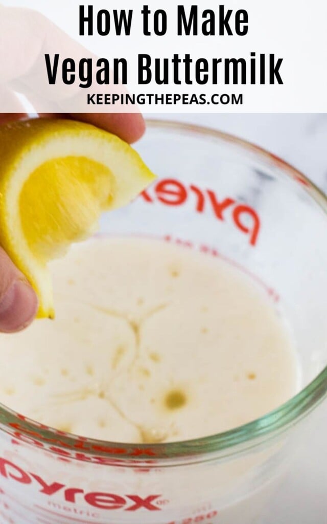 hand squeezing lemon into milk in a measuring cup